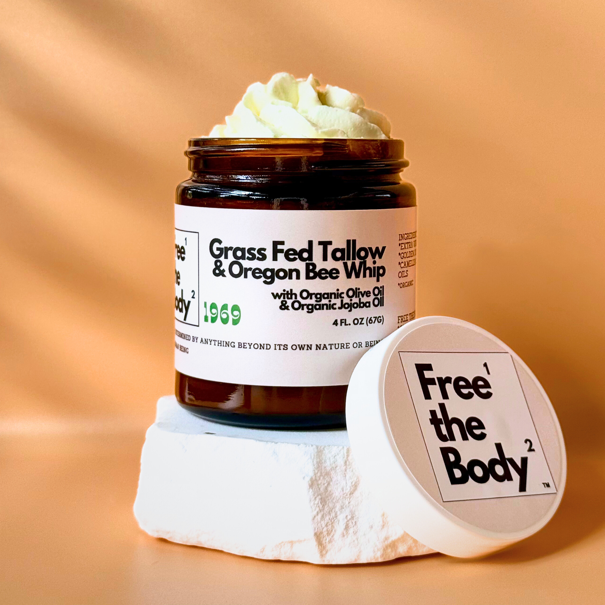 Jar of Grass Fed Tallow & Oregon Bee Whip with a white lid on a beige background