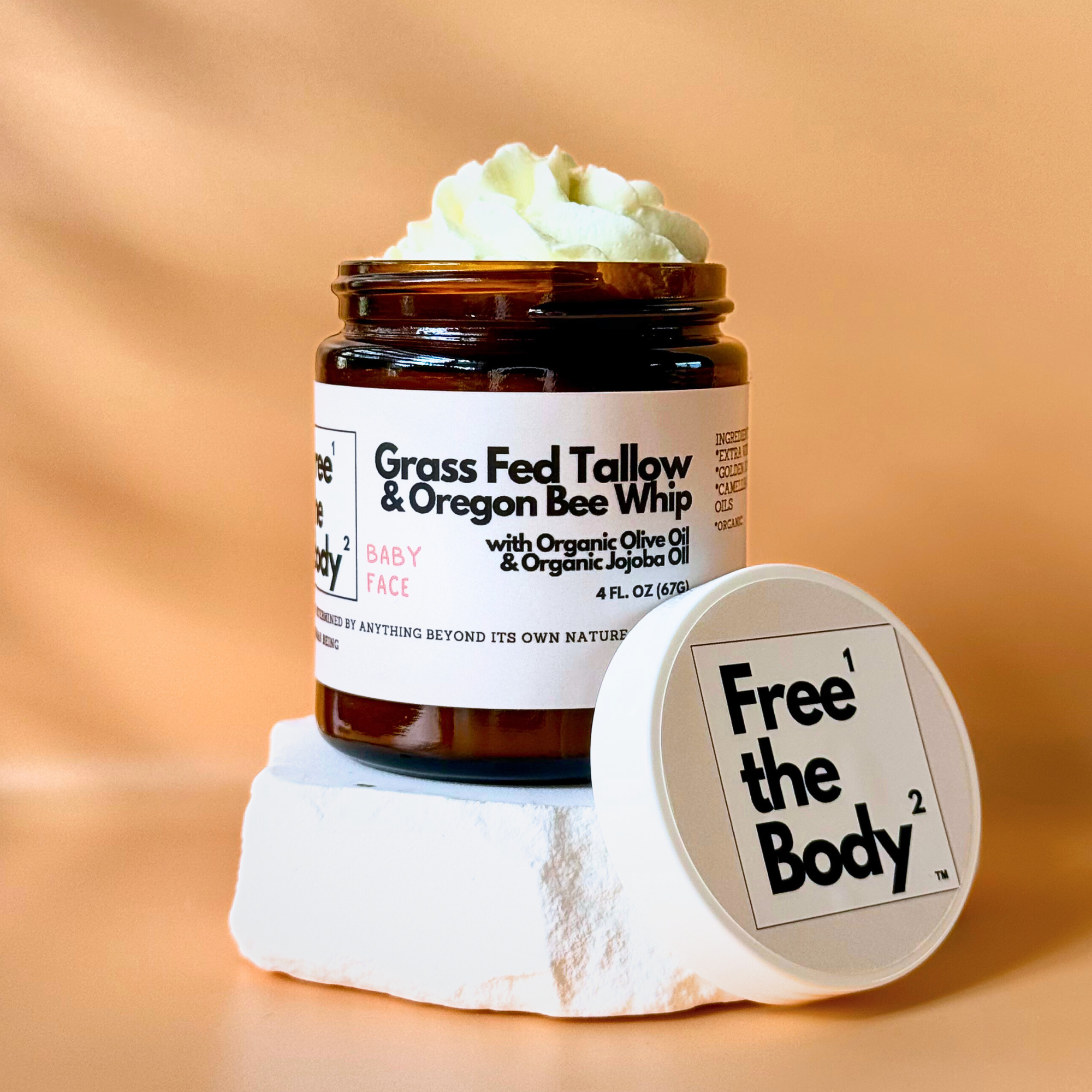 Jar of 'Grass Fed Tallow & Oregon Bee Whip' by Free the Body on a beige background