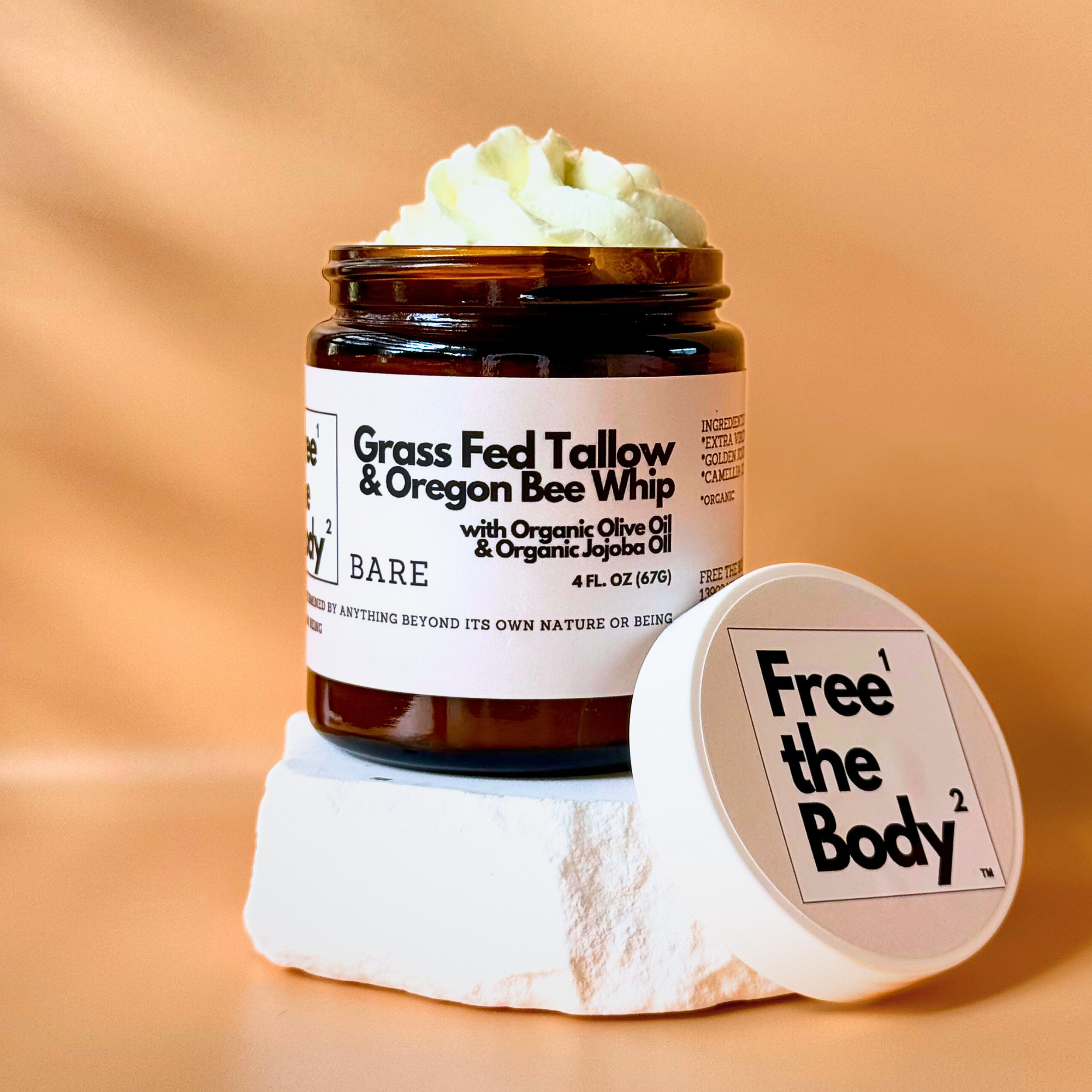 Jar of 'Grass Fed Tallow & Oregon Bee Whip' with a visible brand label on an orange background