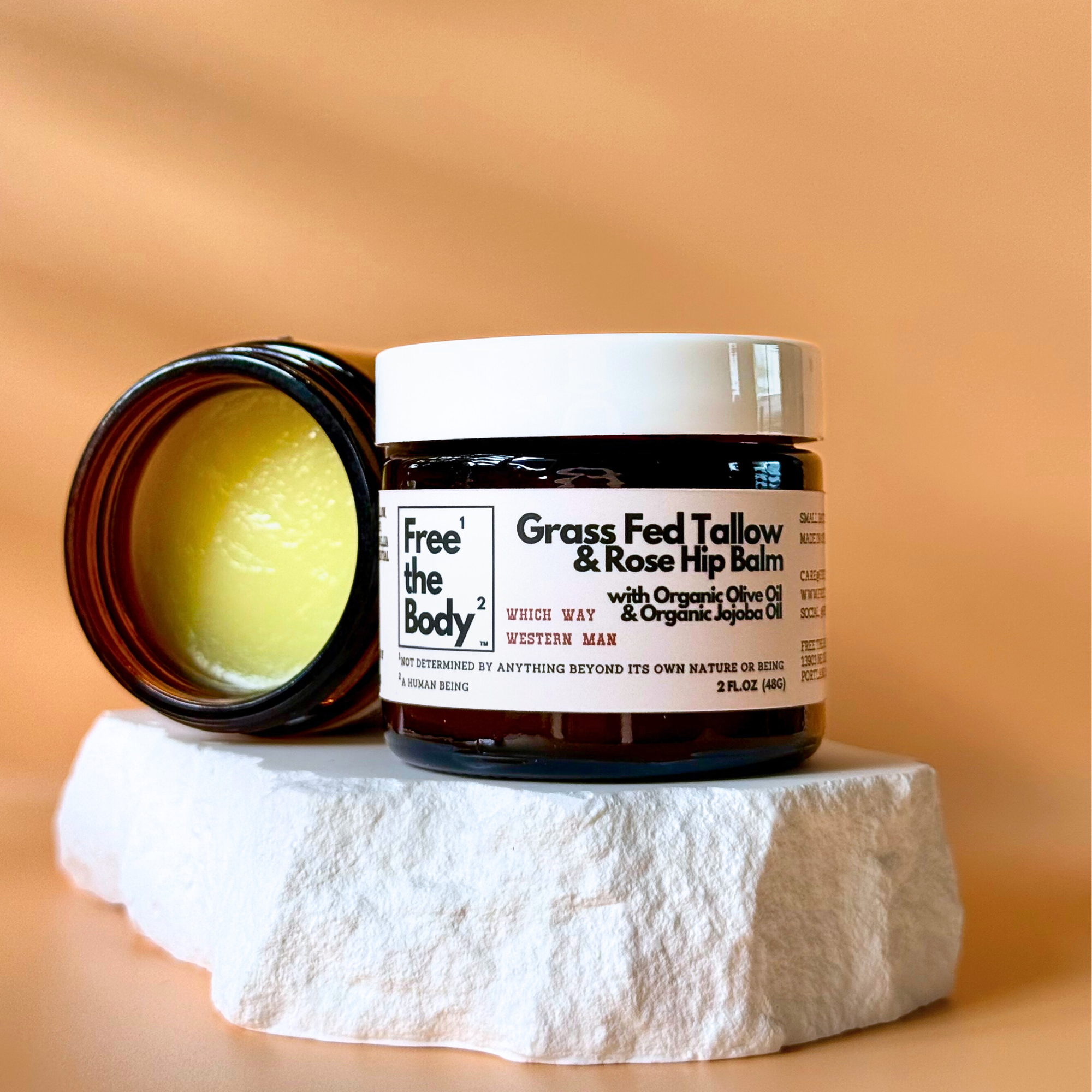 Balm jar with a white label on a stone surface against an orange background